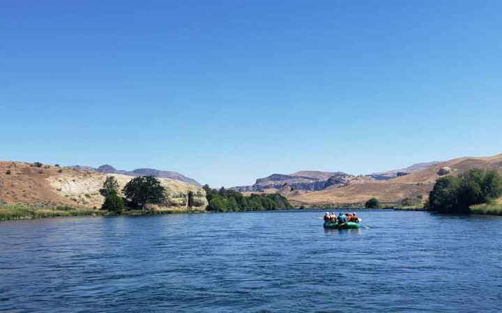 a group of girls float down river on rafting expedition with outward bound